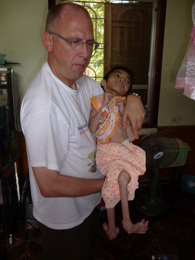 Rolf Biniek mit einem drei Jahre alten Mädchen, das nur 5 kg wiegt